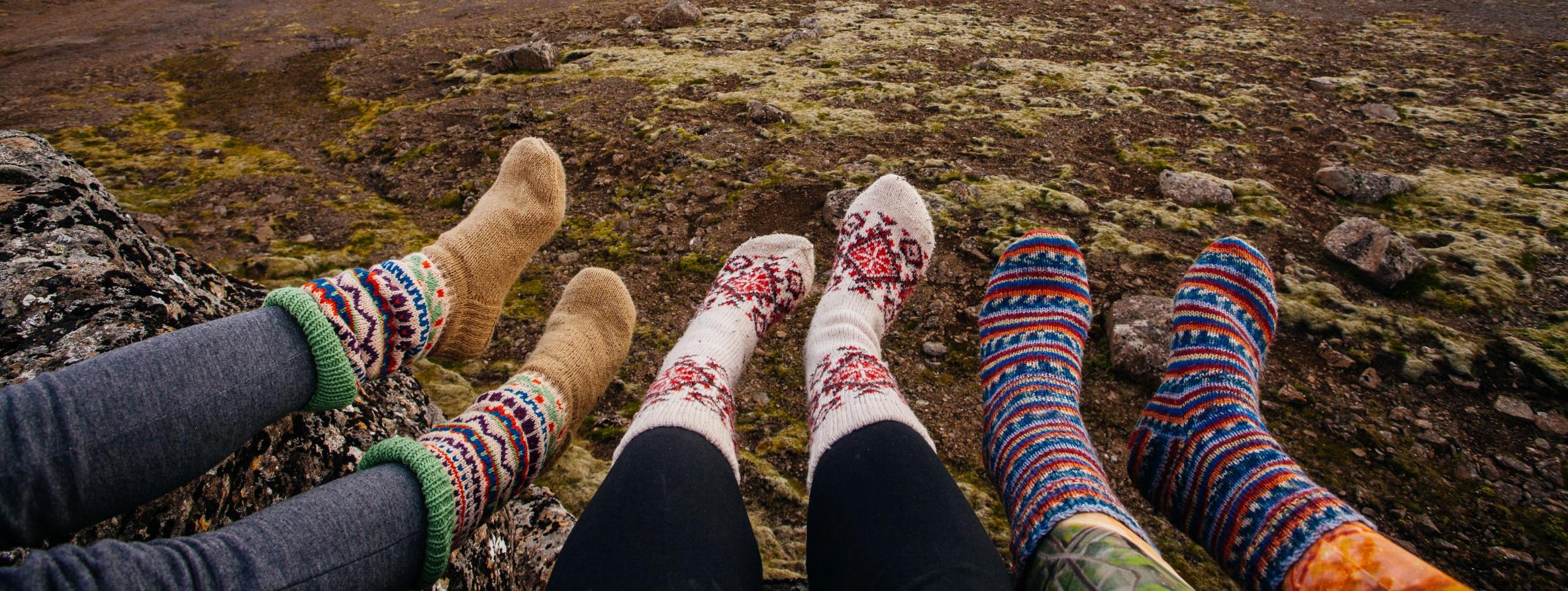 Tres personas mostrando sus calcetines de lana