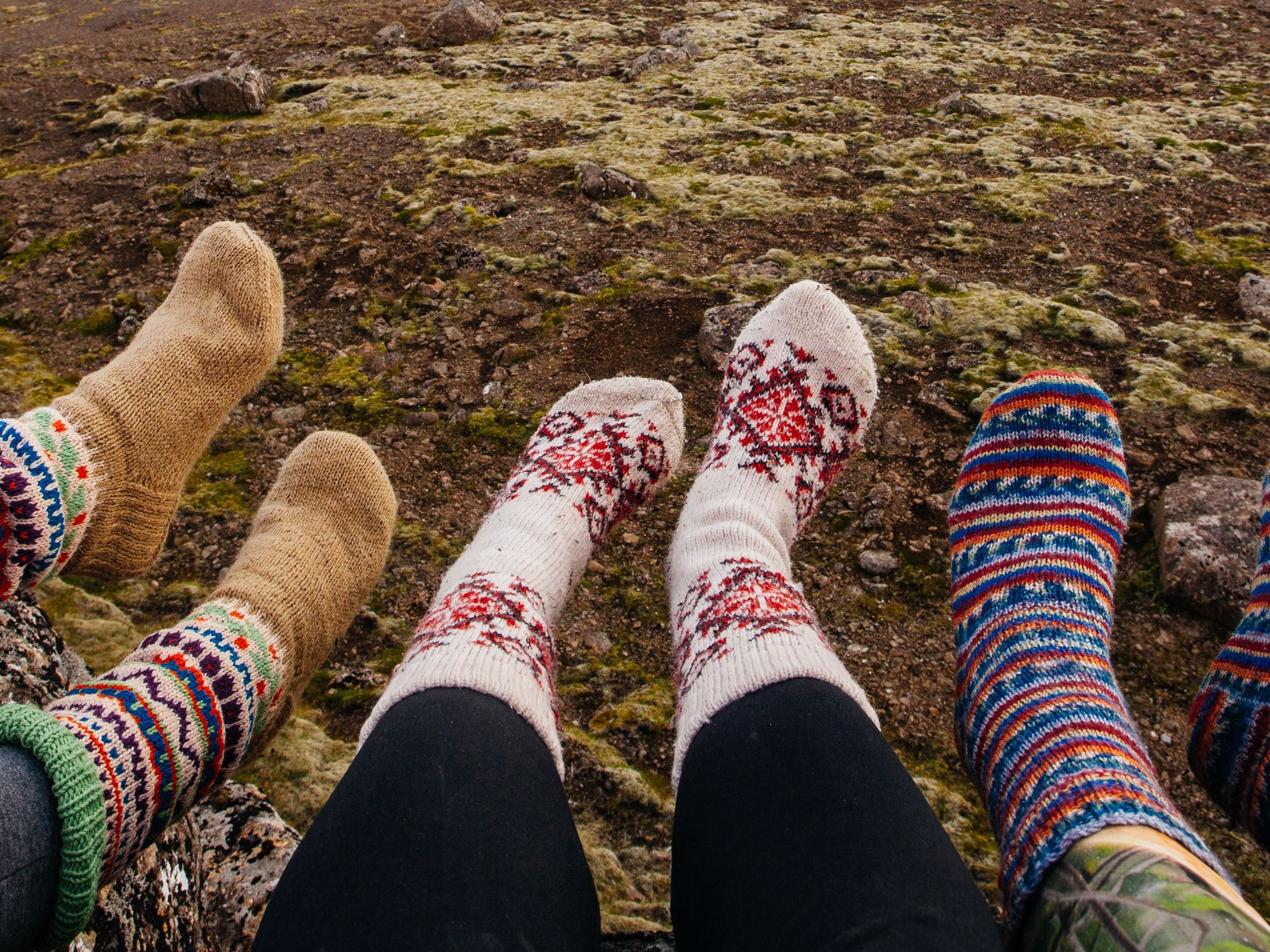 Tres personas mostrando sus calcetines de lana
