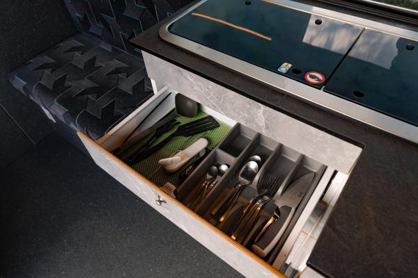 a kitchen drawer filled with utensils and a towel .