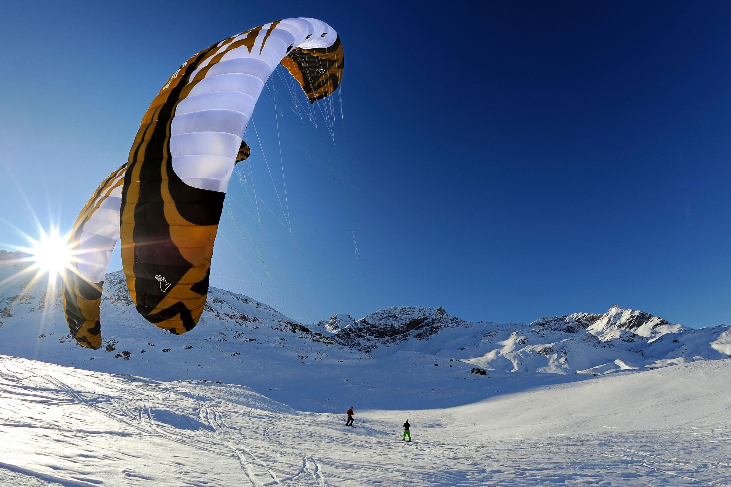 Two people snowkiting