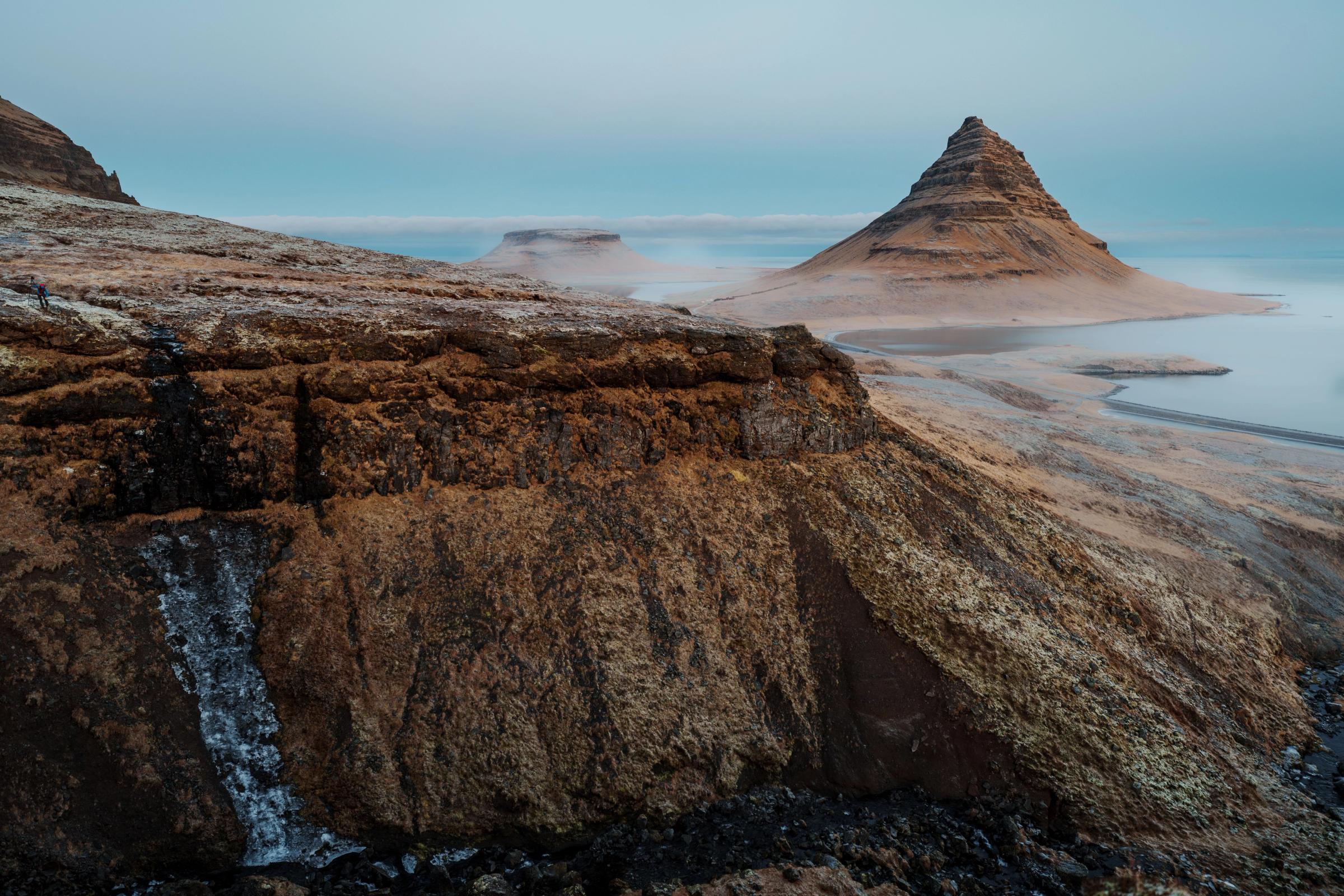 paisaje de un acantilado y montaña con niebla