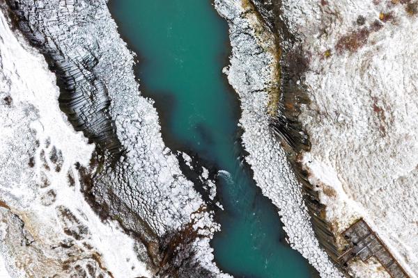 una vista aérea de un río rodeado de nieve y rocas