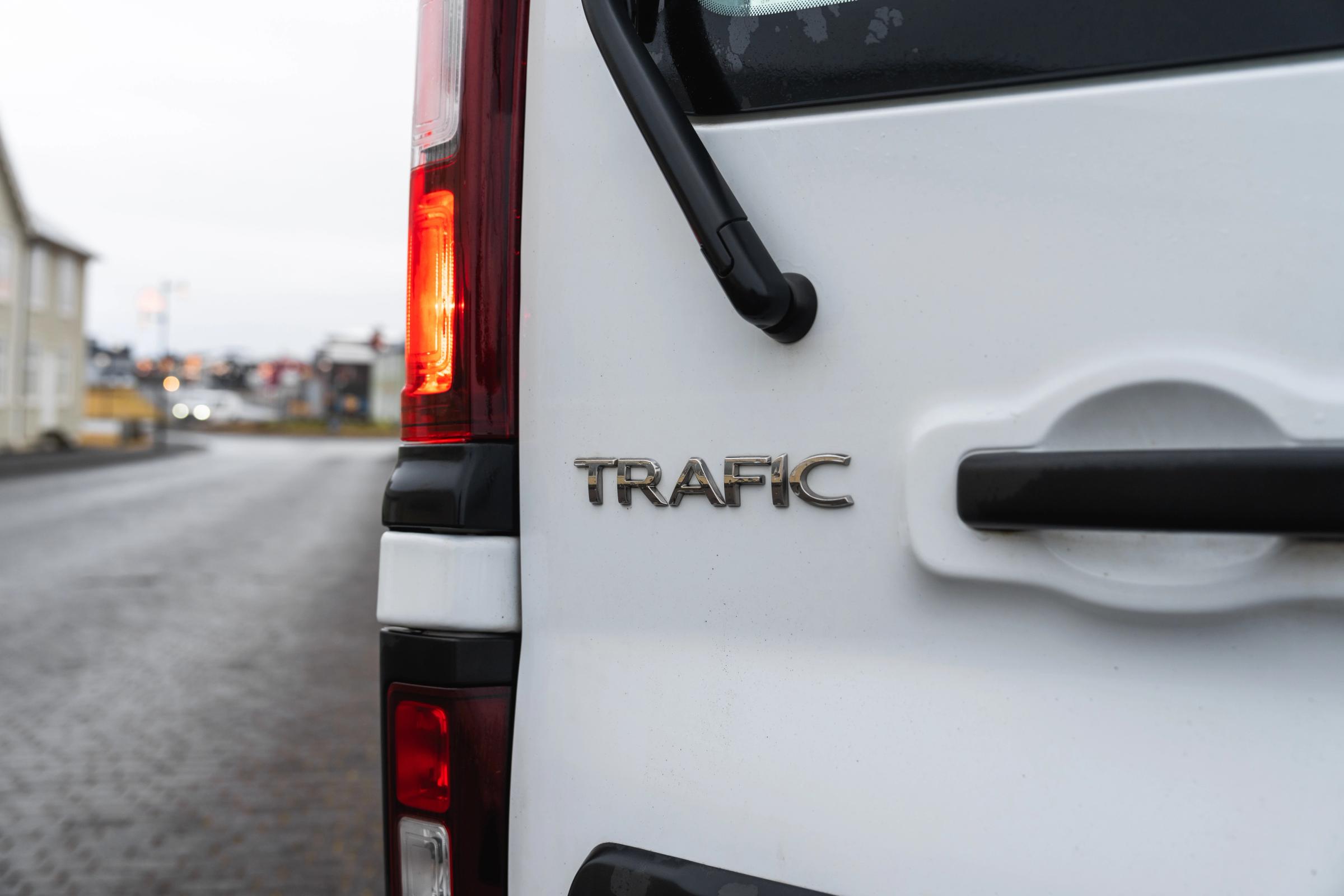 Primer plano del emblema trasero, el piloto y la manilla de la puerta de un monovolumen Renault Trafic