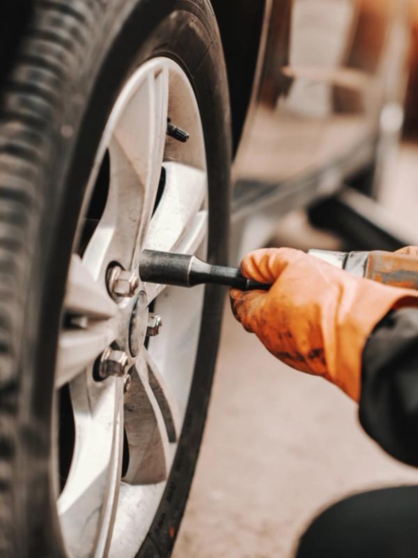 a mechanic is working on the engine of a car in a garage .