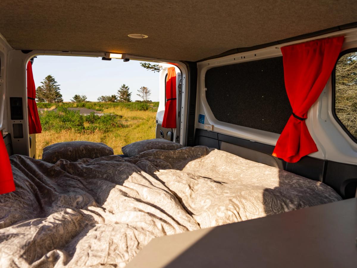Cama vista desde la cocina Cama que ocupa todo el ancho de la parte trasera, vista desde el lateral de la encimera de la cocina