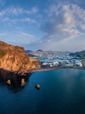 an aerial view of a the Westman islands in the middle of the ocean at sunset.