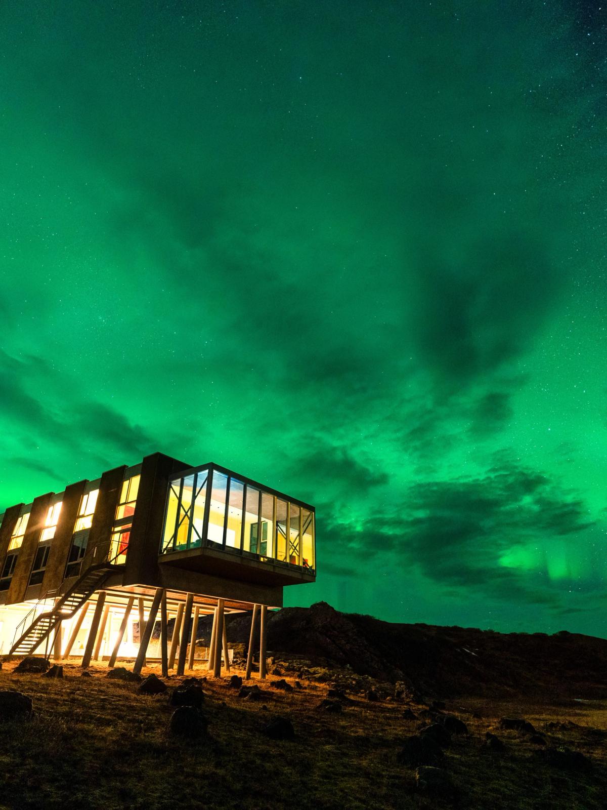 Northern lights glowing over luxury hotel in Iceland