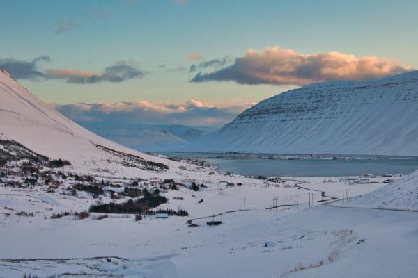 a snowy landscape with a lake and mountains in the background