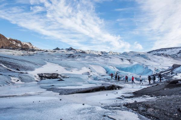 a group of people walking on a big glacier