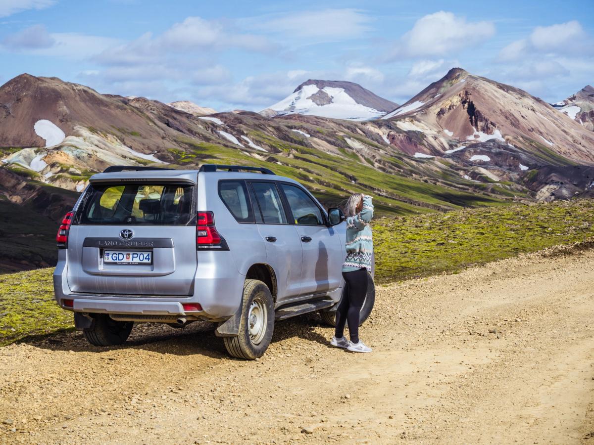 Land Cruiser – Heckansicht Toyota Land Cruiser in der Dreiviertelansicht von hinten auf einer Schotterstraße mit Bergen im Hintergrund