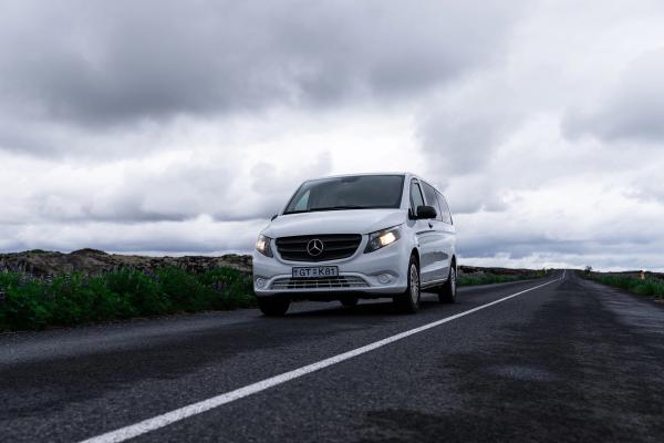Mercedes Vito a white mercedes van is driving down a road .