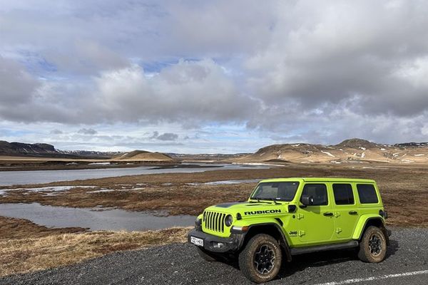 Jeeo verde aparcado en el andén de la carretera