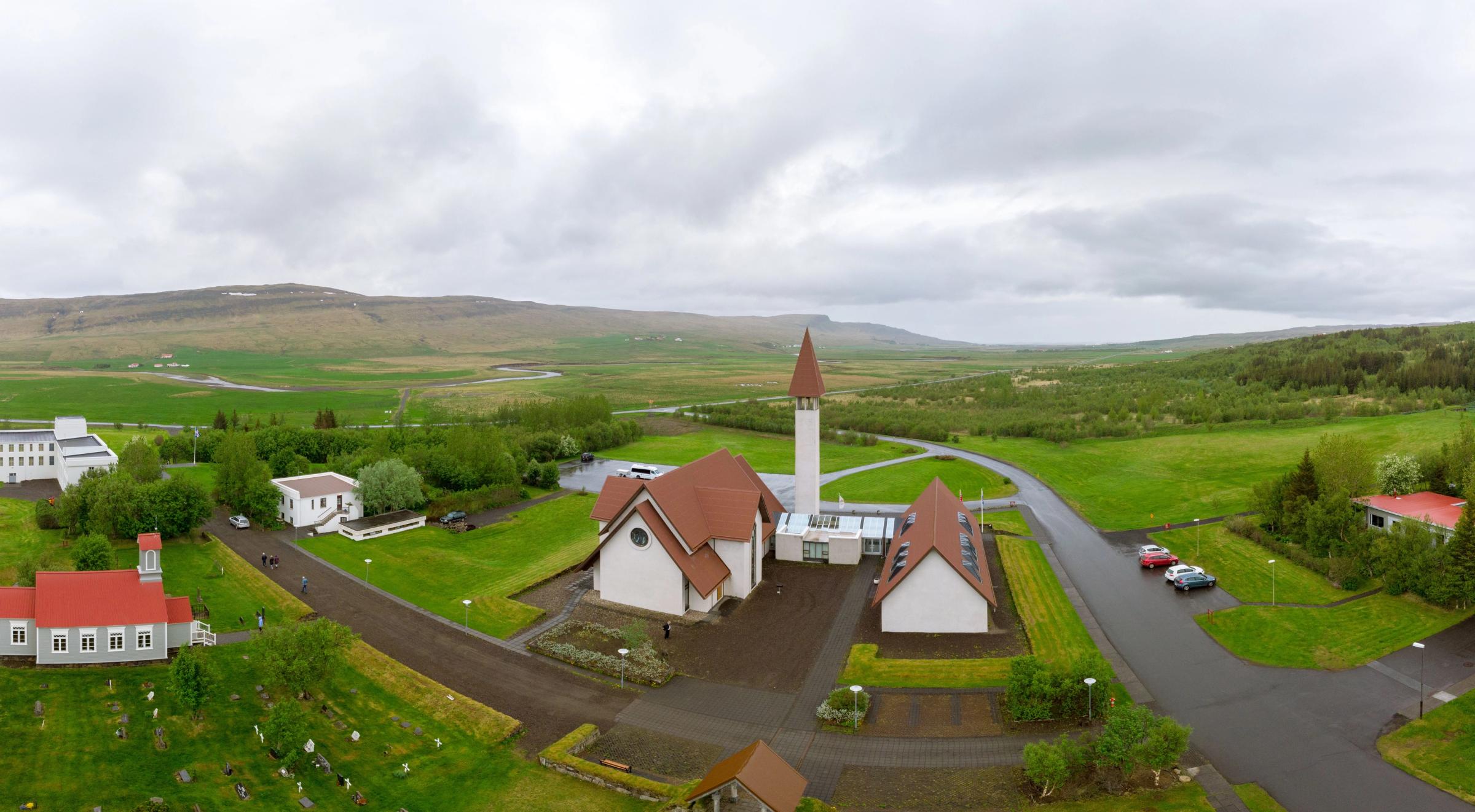 una vista aérea de una iglesia en medio de un campo con montañas al fondo.