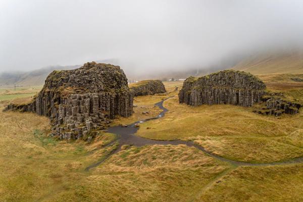 small clusters of basalt column formations in a grass field