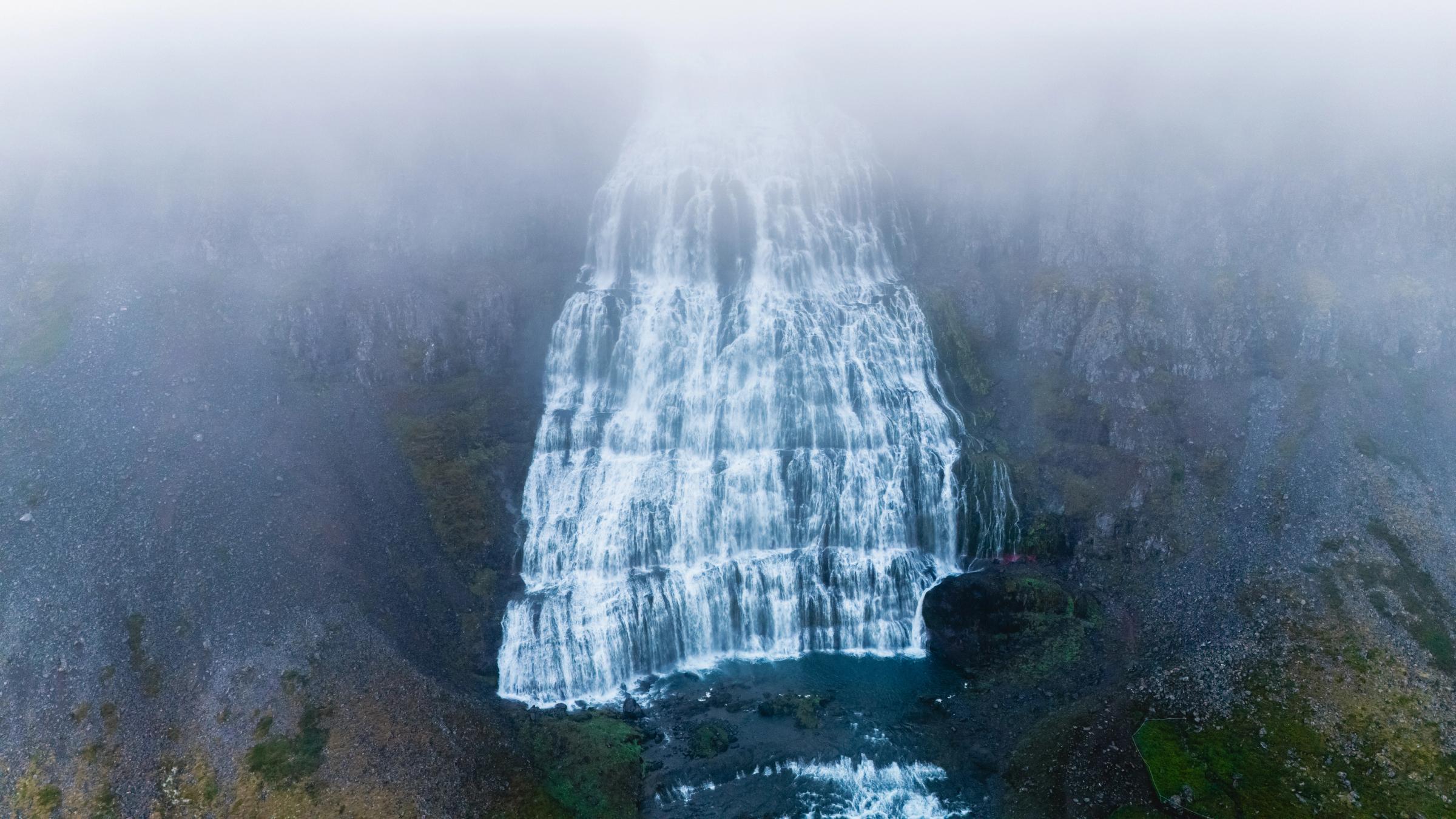 an aerial view of a waterfall in the fog .