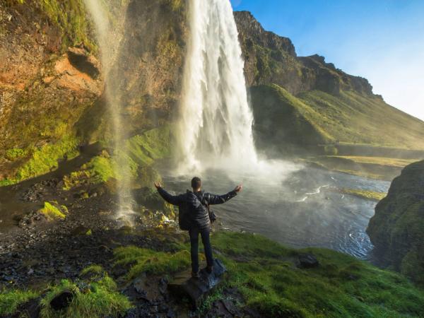 Man under Seljalandsfoss waterfall