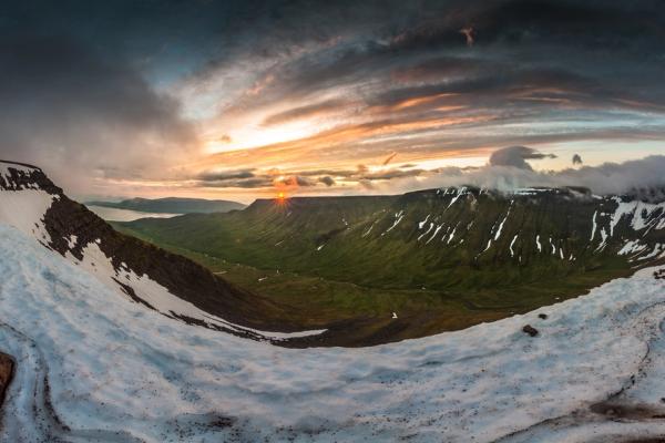 a panoramic view of a Esja mountain valley at sunset