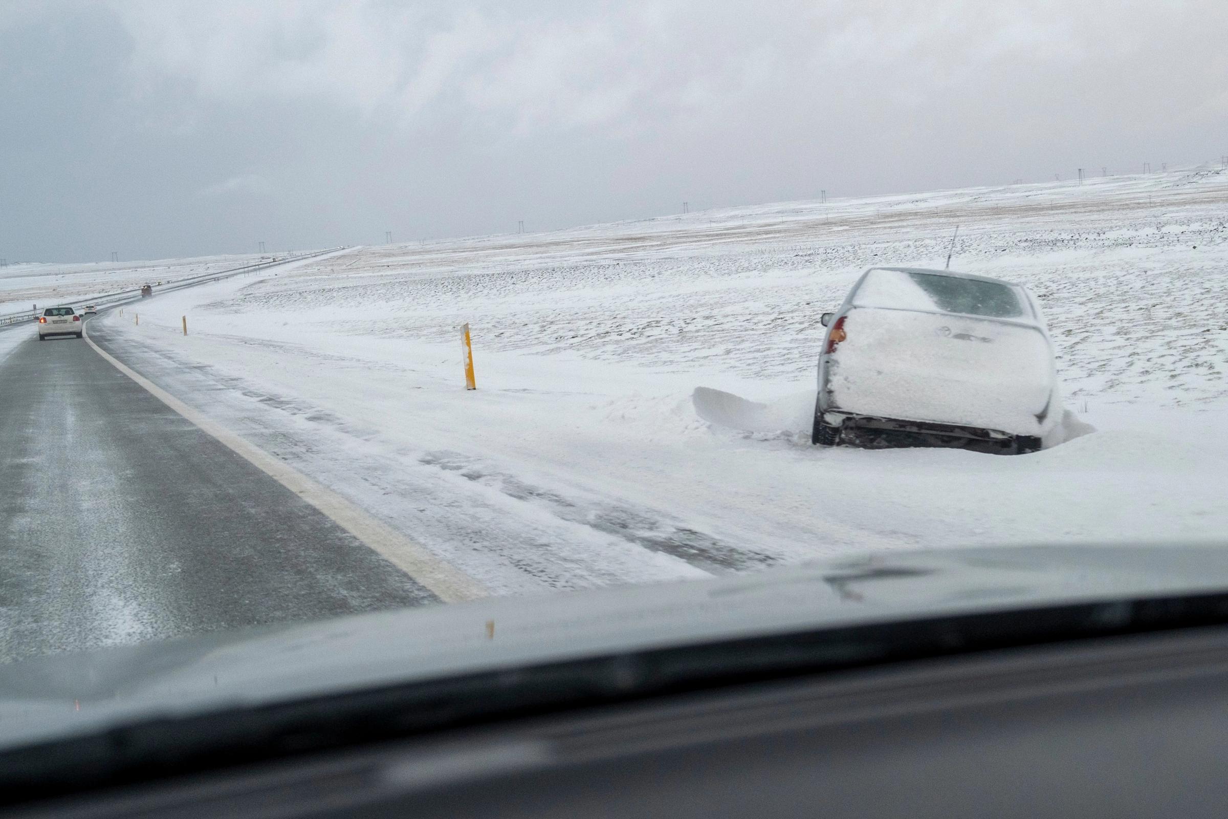 Coche atrapado en la nieve al lado de la calzada del Ring Road