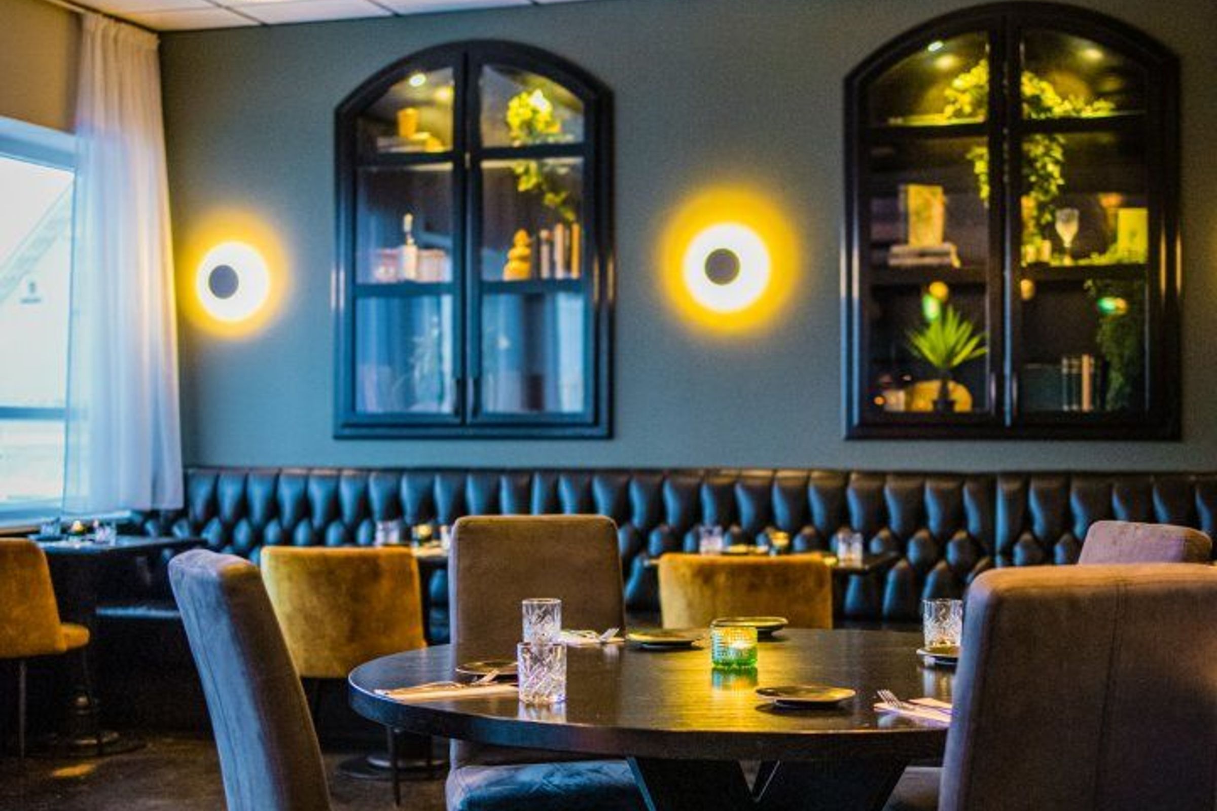 Mulaberg Bistro & Bar in Akureyri Lit restaurant room where you can see beautiful round tables, cozy space