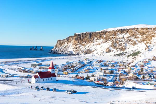 a coastal town covered by snow with a white and red church