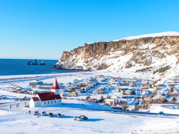 there is a church in the middle of a snow covered field .