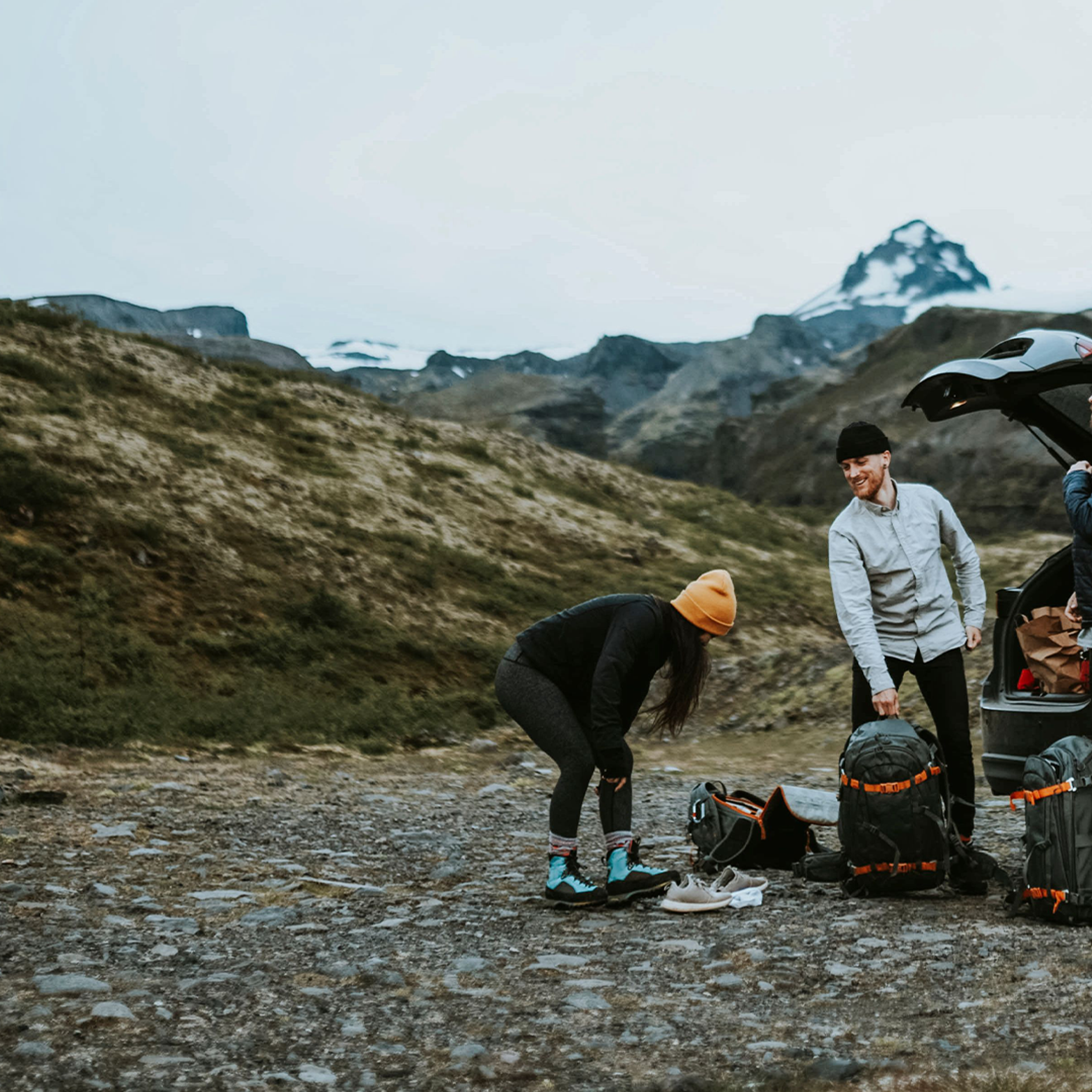 Three friends with their baggage outside their car rental in Iceland