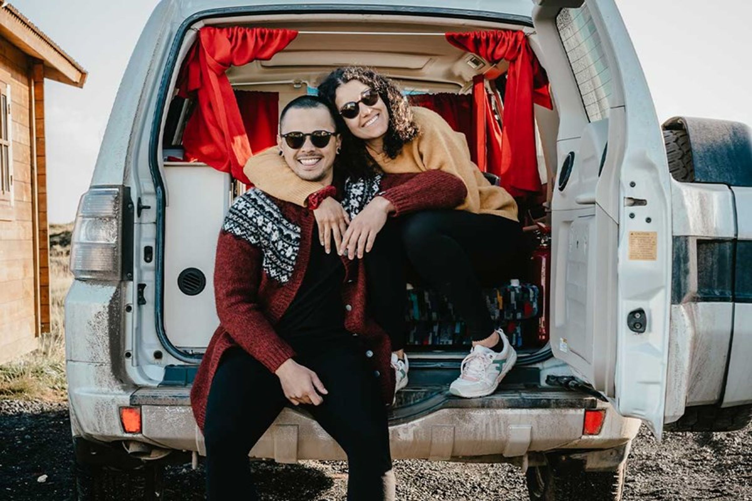 a man and a woman are sitting in the back of a van in iceland.