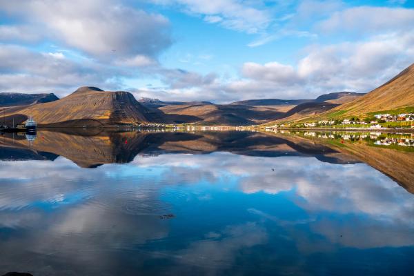un pueblo a la orilla de una masa de agua que se ve reflejado en esta