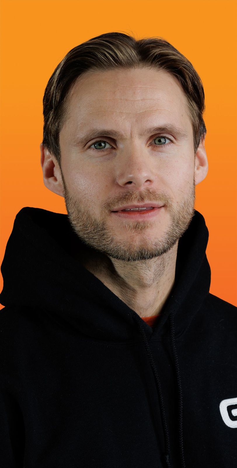 a man wearing a black hoodie with the letter g on it