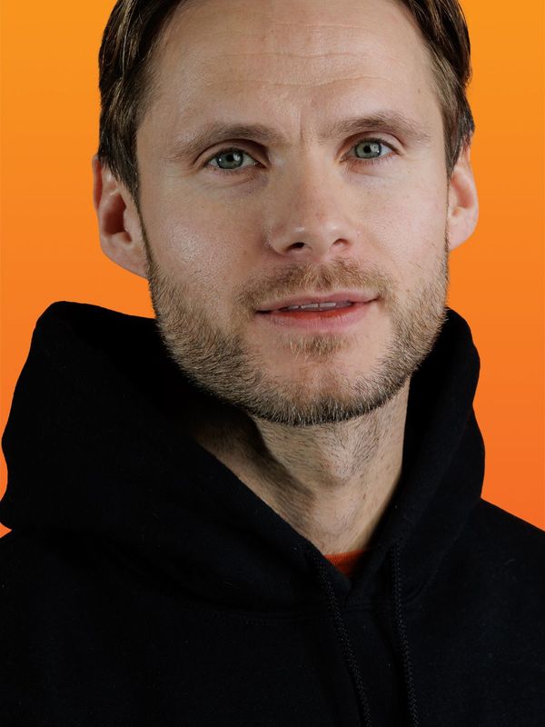 a man wearing a black hoodie with the letter g on it