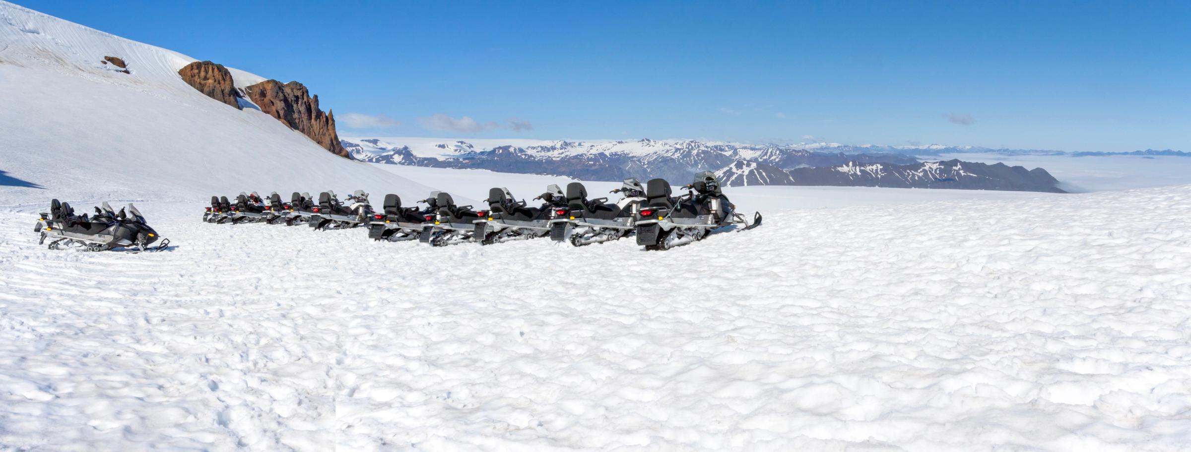 snowmobiles parked on top of a glacier