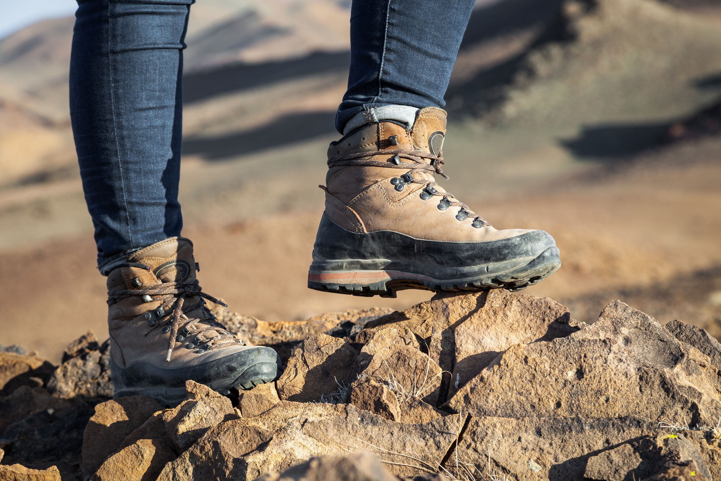 una persona con botas de senderismo está parada sobre una roca.