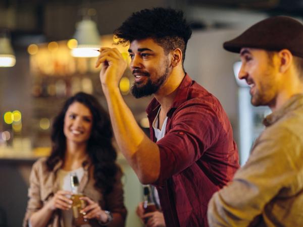 Grupo de amigo jugando a los dardos