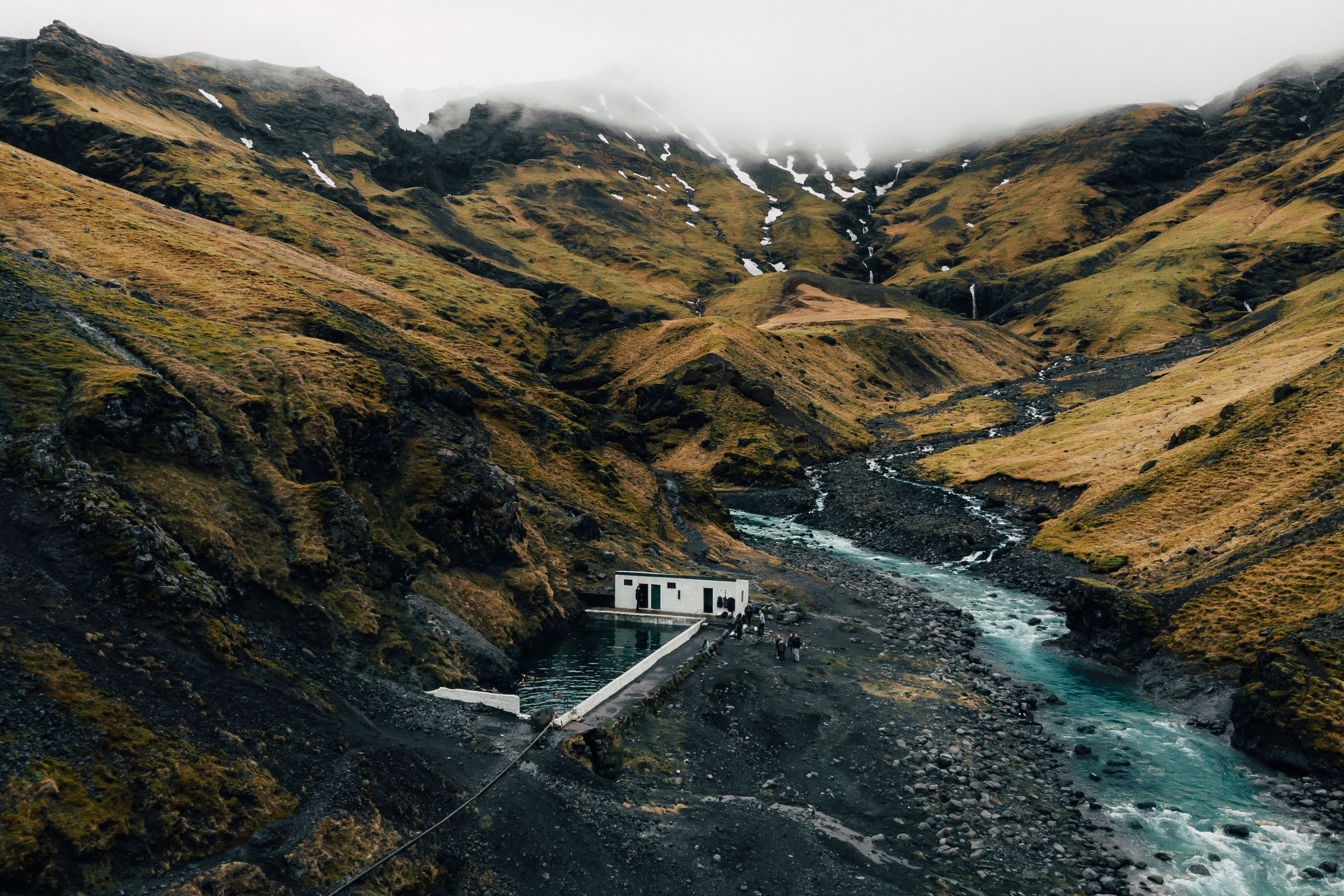 an aerial view of a house in the middle of a valley next to a river .