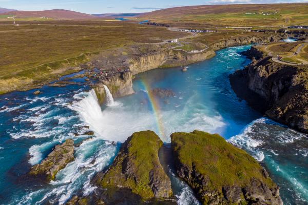 an aerial view of a waterfall with a rainbow in the water .