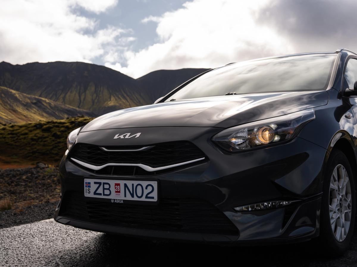 Primer plano frontal del Ceed Wagon Parrilla delantera y faro de un Kia Ceed familiar con un paisaje montañoso al fondo