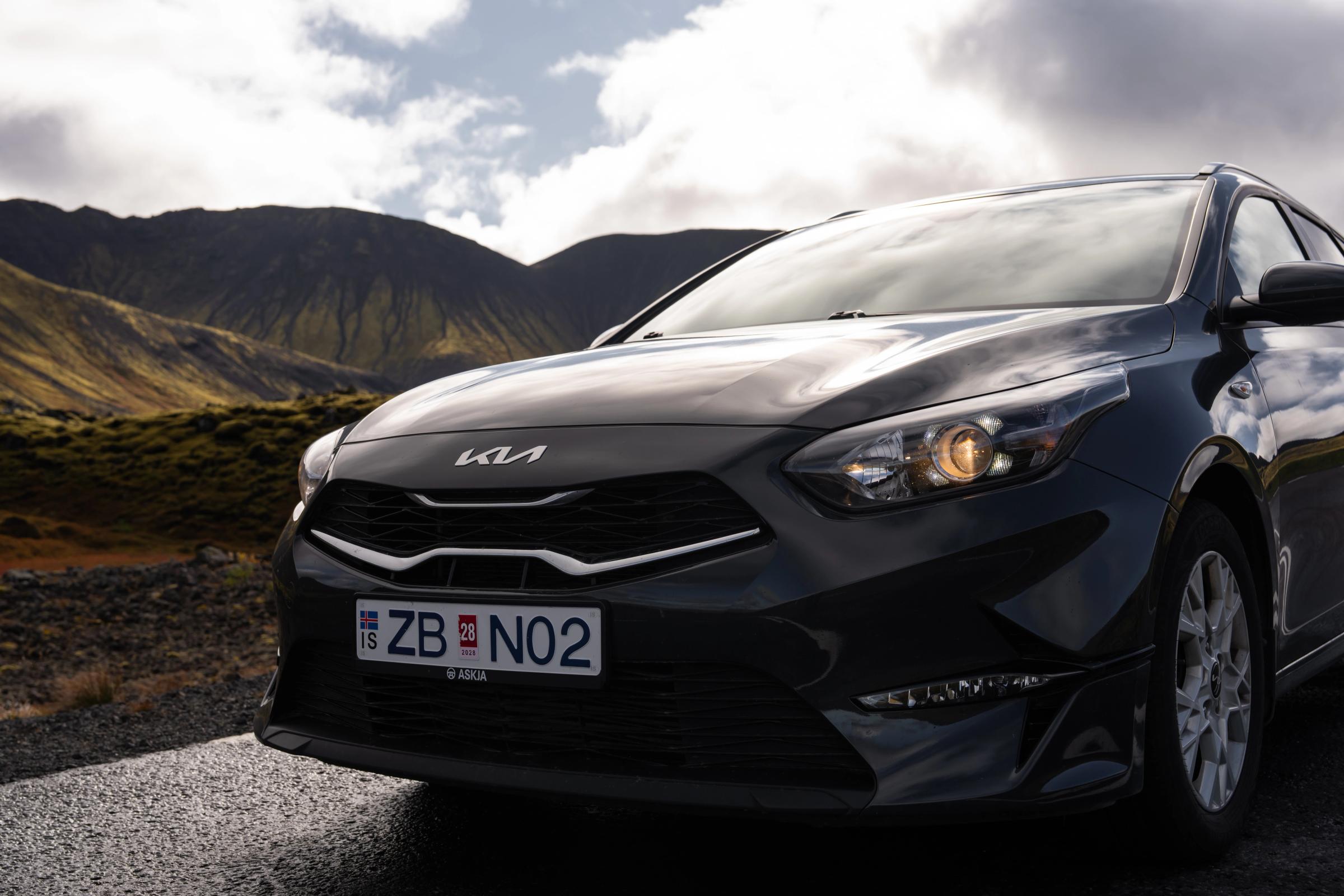 Primer plano frontal del Ceed Wagon Parrilla delantera y faro de un Kia Ceed familiar con un paisaje montañoso al fondo