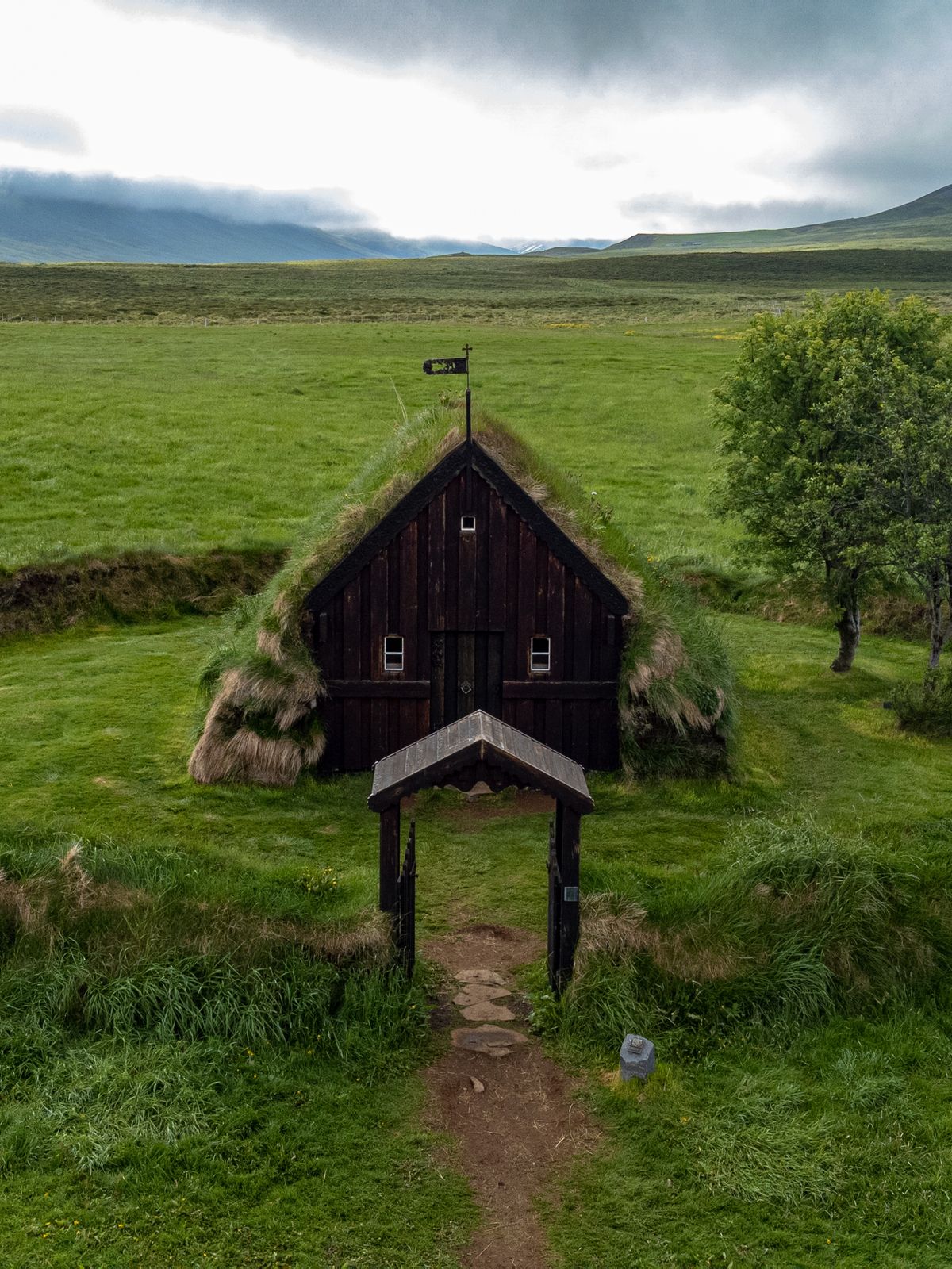 an aerial view of a small church in the middle of a grassy field .