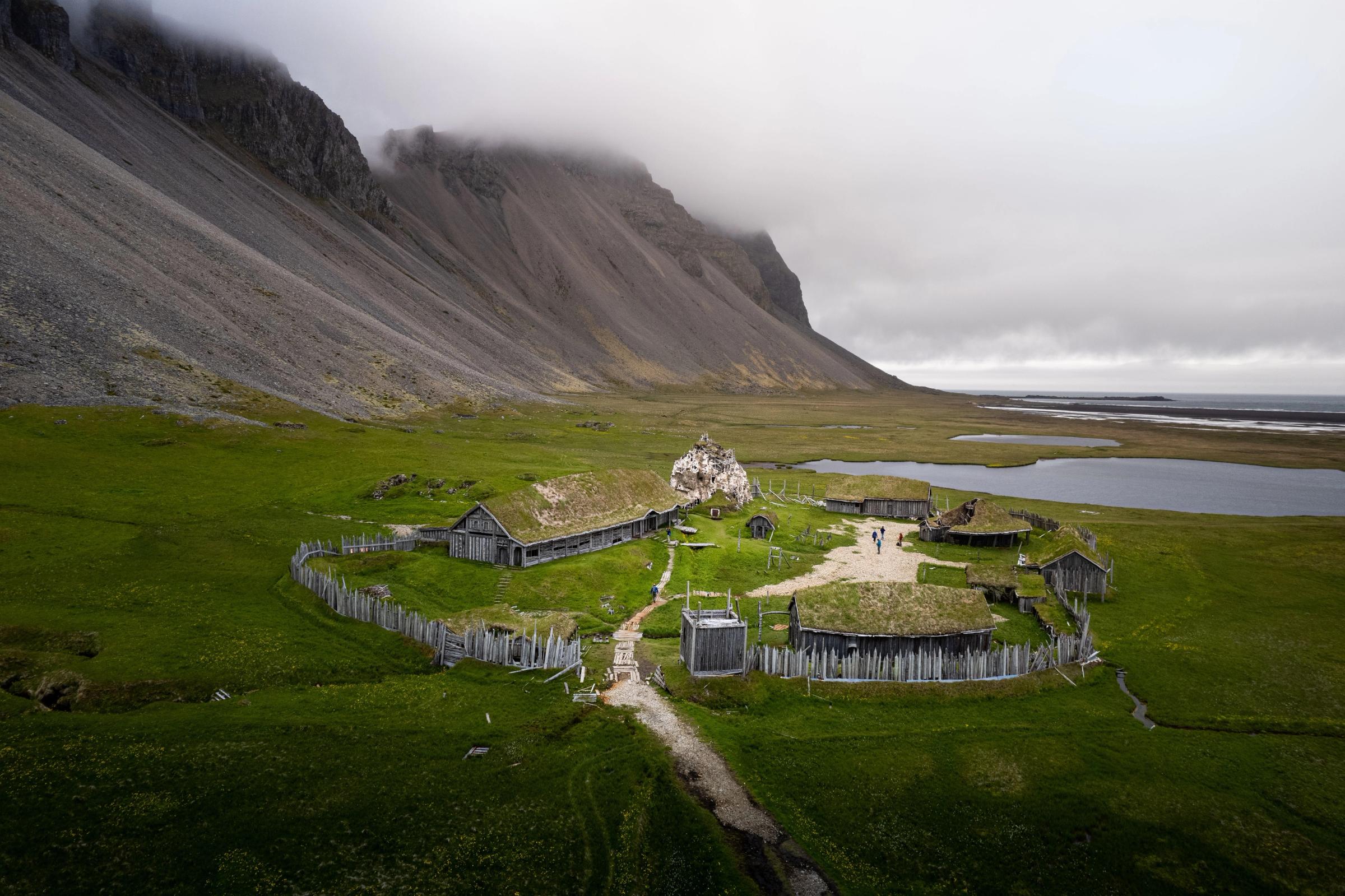 Pueblo vikingo y sus paisajes verdes en Islandia rodeados de colinas rocosas en un clima nublado
