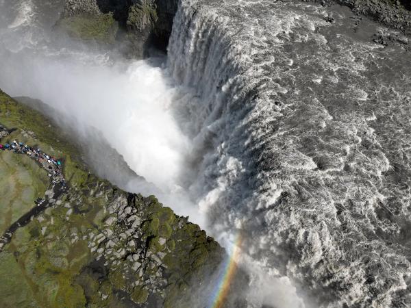 an aerial view of Dettifoss waterfall with a rainbow in the middle .