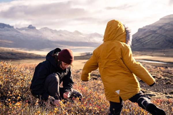 a man and a child are playing in a field of flowers .