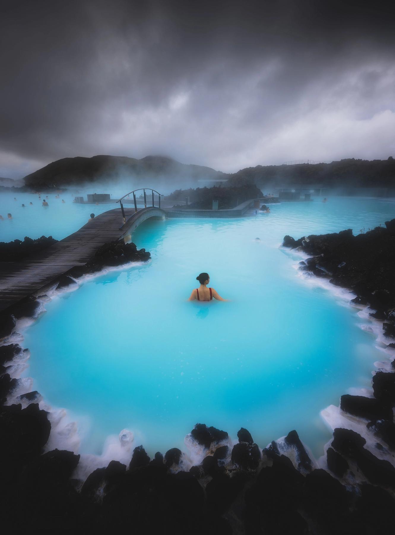 a woman is swimming in a pool of blue water