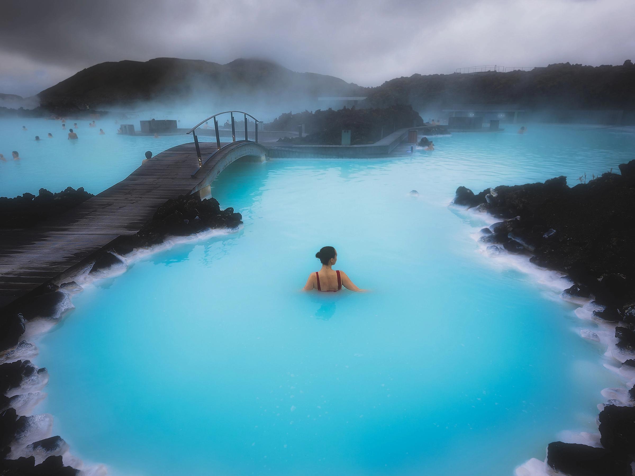 a woman is swimming in a pool of blue water