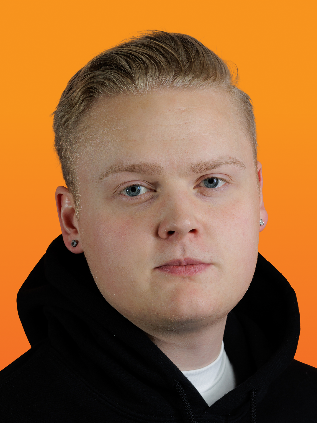 a young man wearing a black hoodie looks at the camera