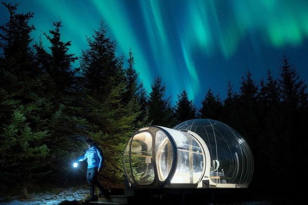 Star Hotel Iceland A transparent bubble tent, known as the 5 Million Star Hotel, set in the serene Icelandic wilderness under a star-studded sky.