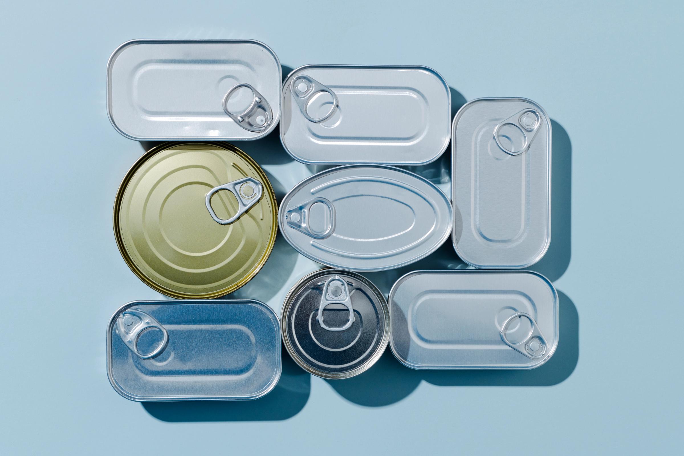 un grupo de latas apiladas unas sobre otras en una superficie azul.