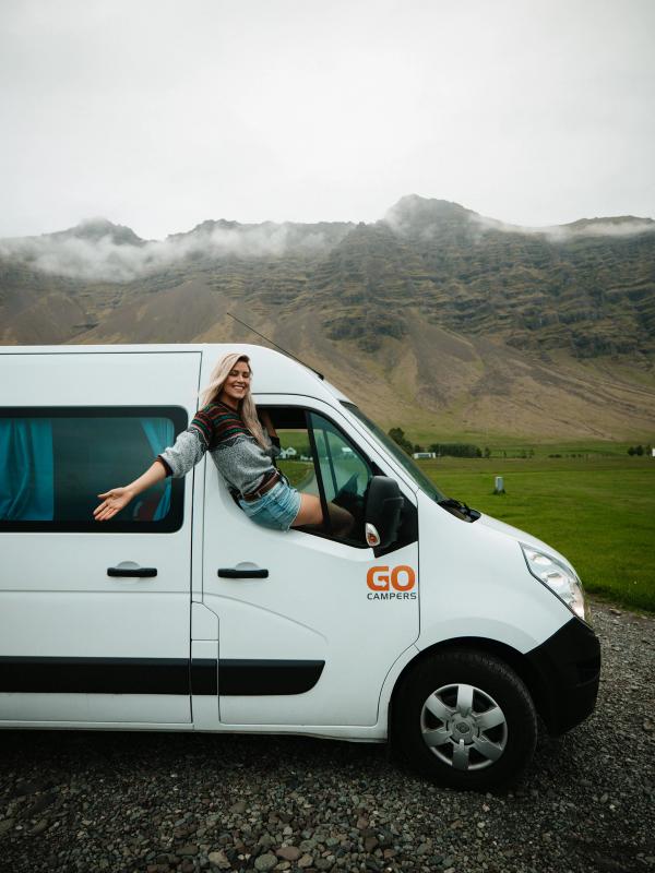 a woman leans out of the window of a go camper van