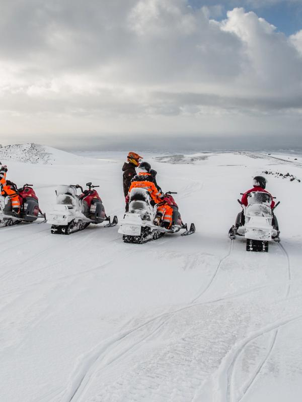 Un grupo de personas monta en moto de nieve.