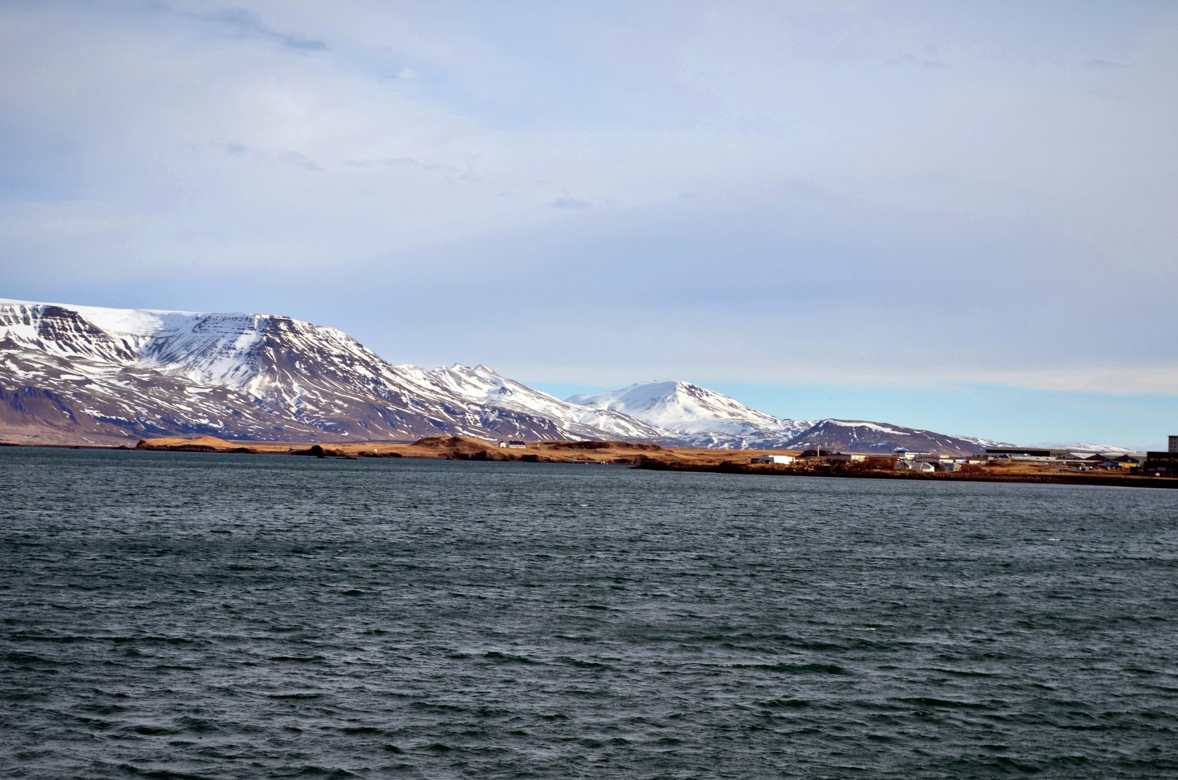 a large body of water with mountains in the background .