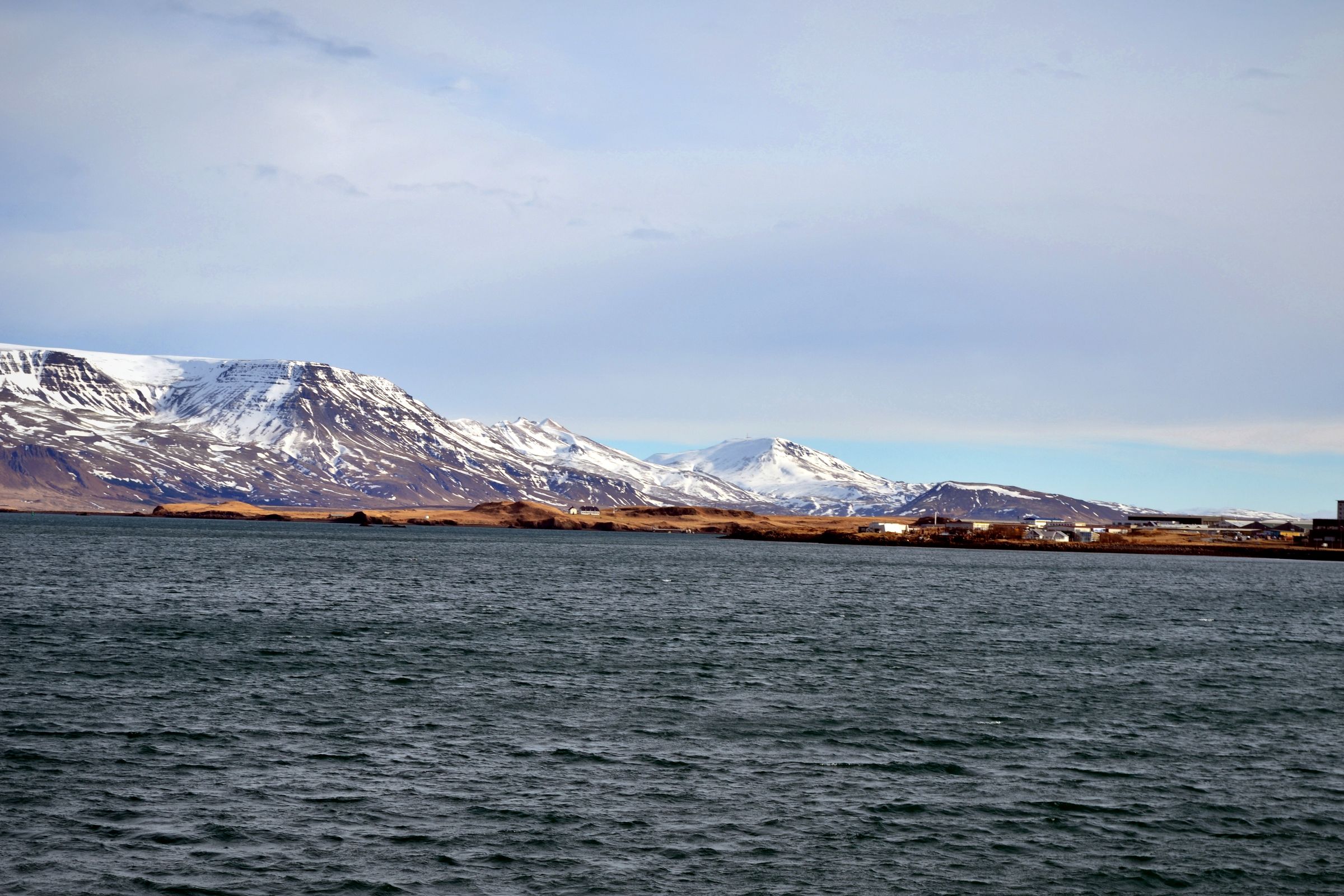 a large body of water with mountains in the background .